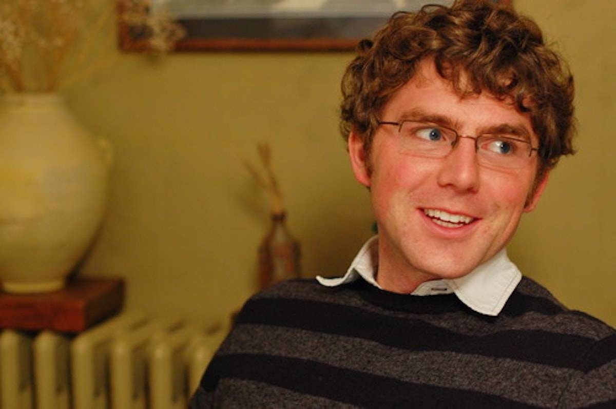 Man with glasses smiling.