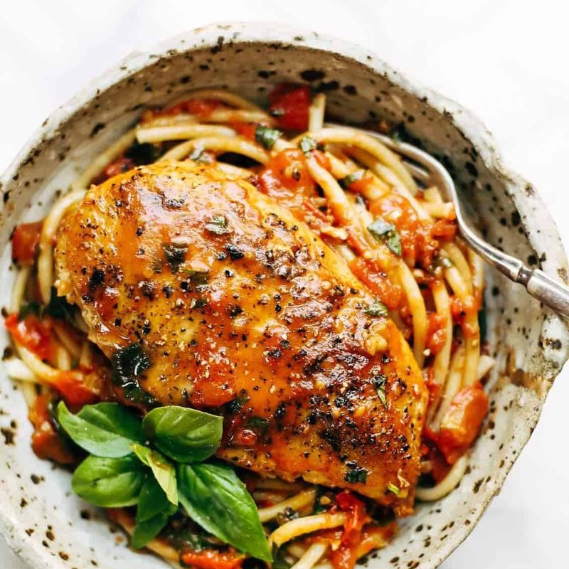 Garlic Basil Chicken in a bowl with pasta and basil.